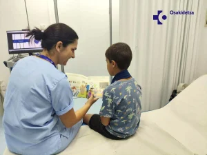 Mujer leyendo un cuento a un niño en un entorno médico
