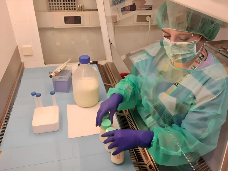 Profesional de la salud manipulando frascos de leche materna en un laboratorio