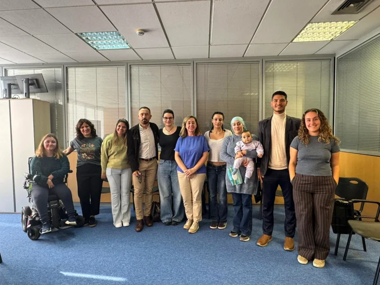 Grupo de personas en una sala de reuniones, algunas con discapacidad.