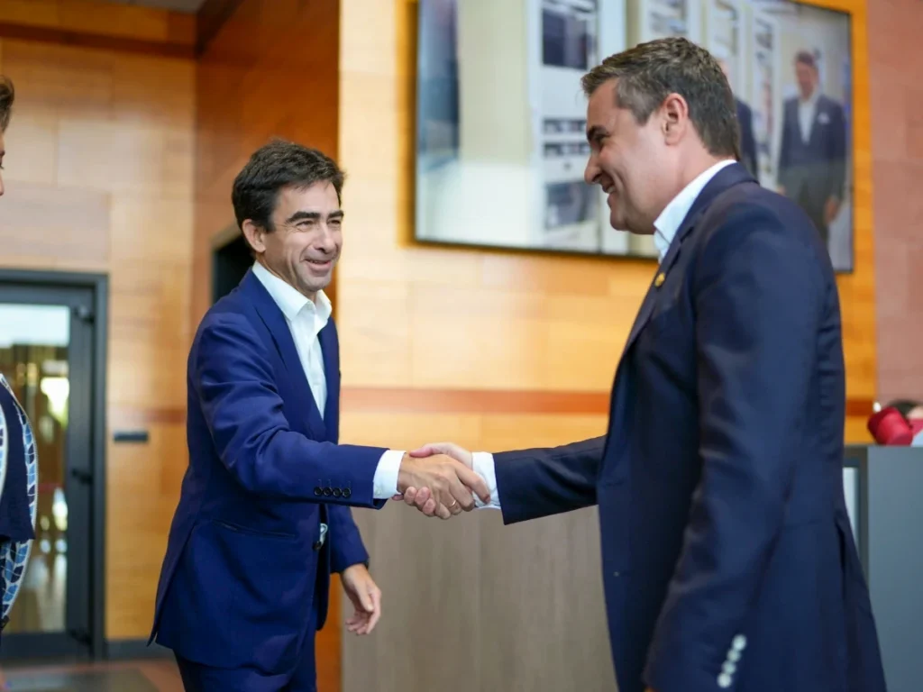 Dos hombres de negocios estrechándose la mano en un entorno moderno.