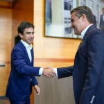 Dos hombres de negocios estrechándose la mano en un entorno moderno.